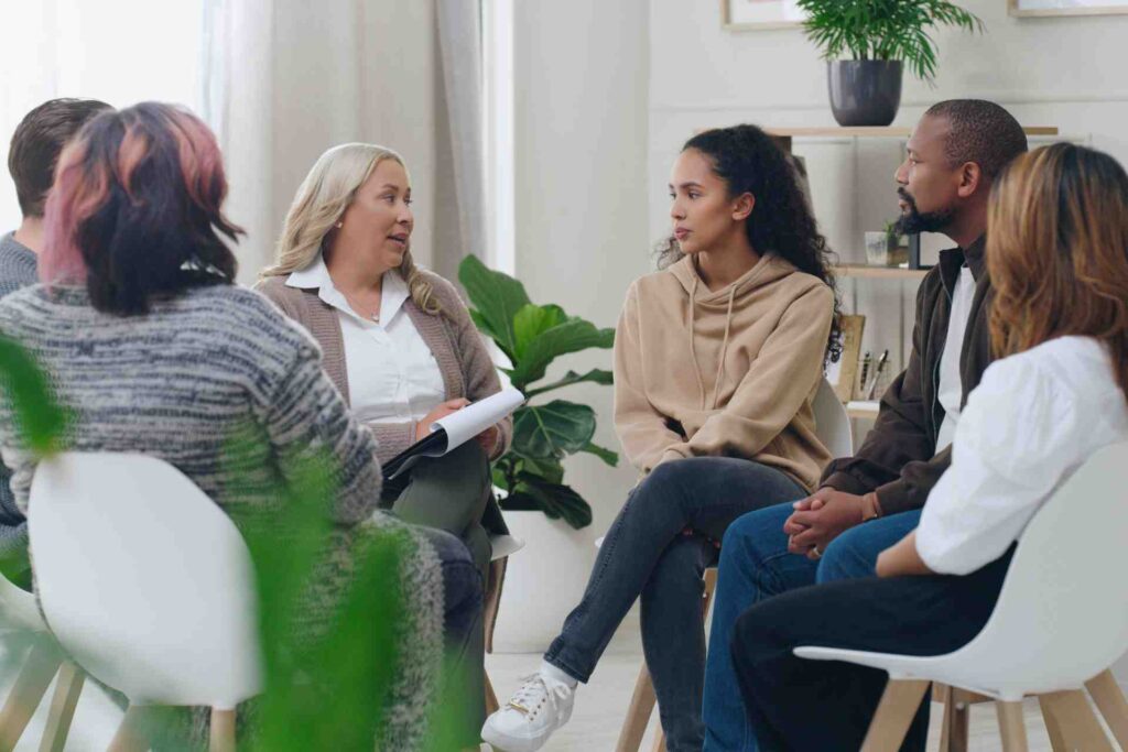 Group of adults participating in a mental health therapy session with a counselor